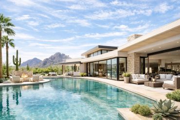 Modern luxury house with a large pool and desert mountains in the background.