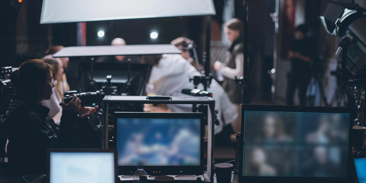 Film crew working behind monitors on a movie set.