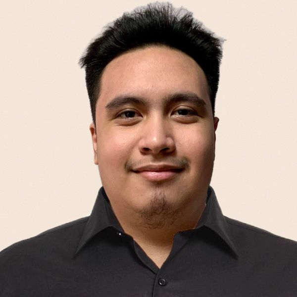 Portrait of a young man with a slight smile in a black shirt.
