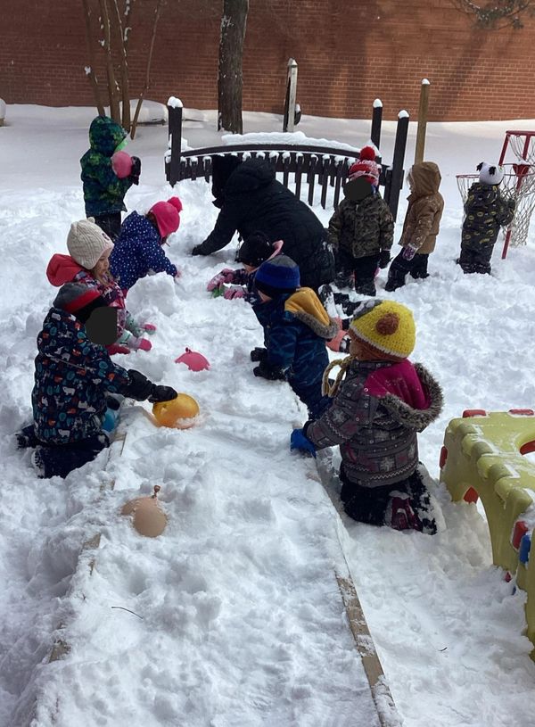 Children playing and building in the snow on a winter day.