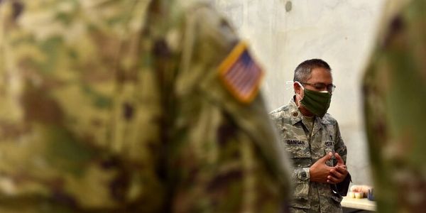 Chaplain saying a prayer with mask on