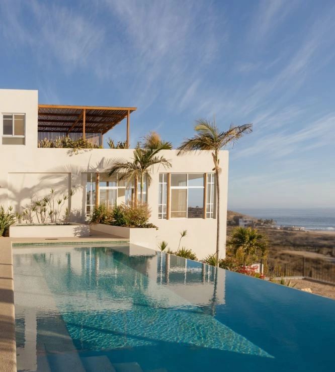 Modern white house with infinity pool and ocean view.