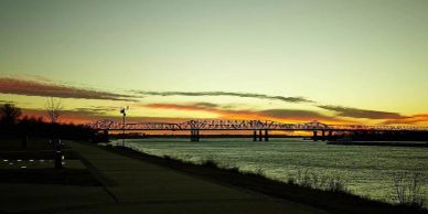 Bridge at sunset over river.