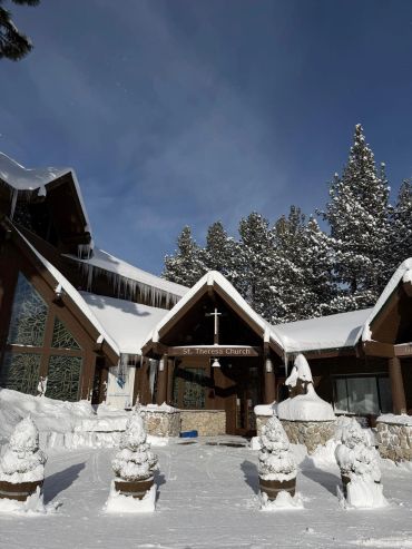 Iglesia nevada con árboles cubiertos de nieve.