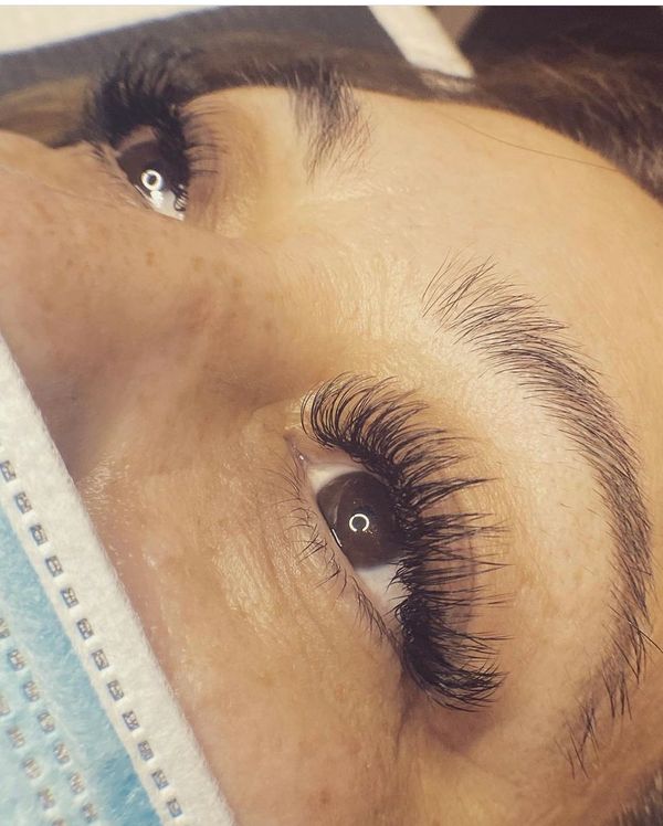 Close-up of eyes with long, thick eyelash extensions and natural eyebrows.
