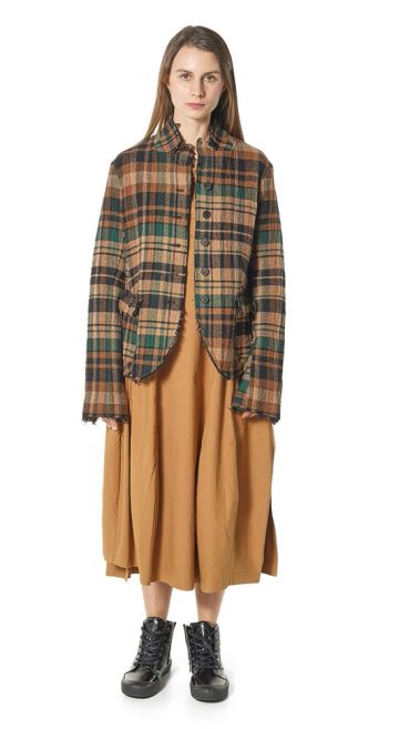 Femme portant une veste à carreaux et une robe marron.