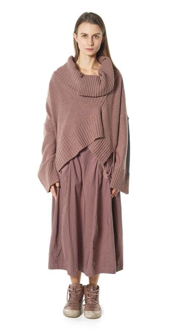 Femme avec un ensemble vieux rose en maille.