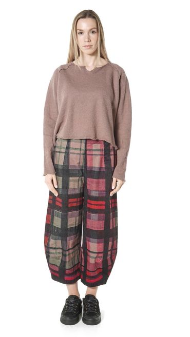 Woman wearing plaid pants and a brown sweater.