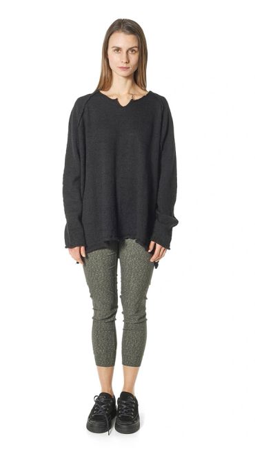 Woman wearing a black oversized sweater and patterned leggings.