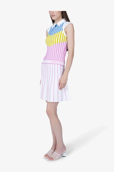Woman wearing a colorful striped sleeveless top and white skirt with stripes.