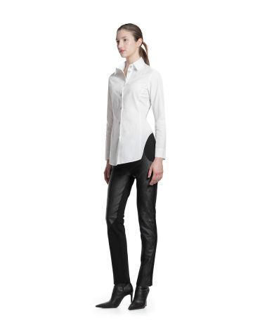 Femme en chemise blanche et pantalon noir.