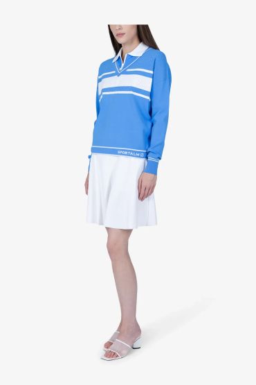 Woman in a blue and white sporty outfit with white sandals.