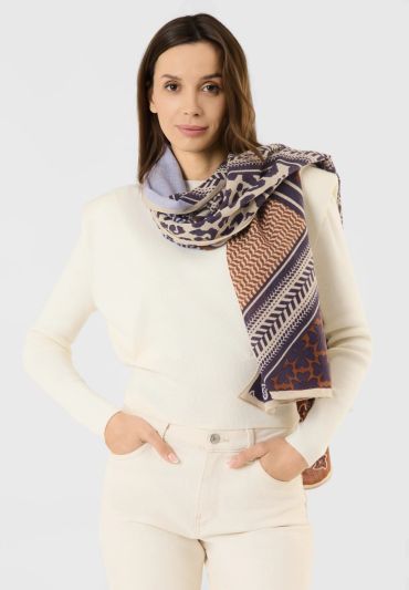 Woman wearing a patterned scarf and white outfit.