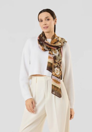 Woman wearing a white sweater and patterned scarf.