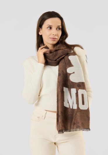 Woman wearing a brown patterned scarf and cream outfit.