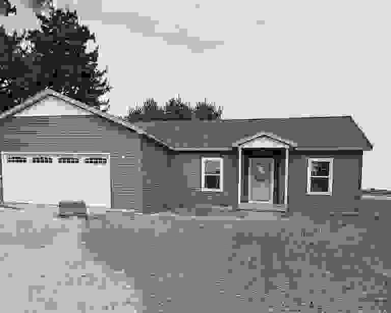 Single-story brown house with white garage and a small front porch.