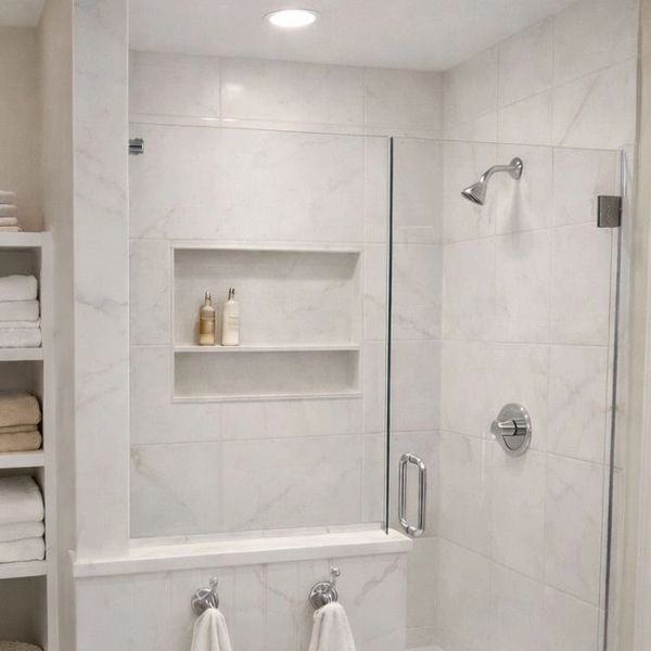 Clean, modern bathroom with glass shower and organized towels.