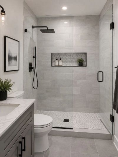 Modern bathroom with glass shower and gray tiles.