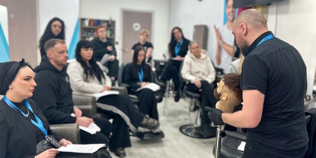 Guest educator teaching attentive barbering students.