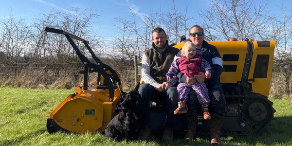 Family sat on yellow machinery in field
