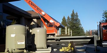 A service crane truck parked next to an outdoor industrial HVAC unit.