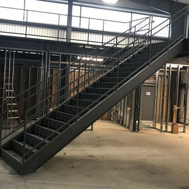 Custom fabricated steel stairs leading to mezzanine.