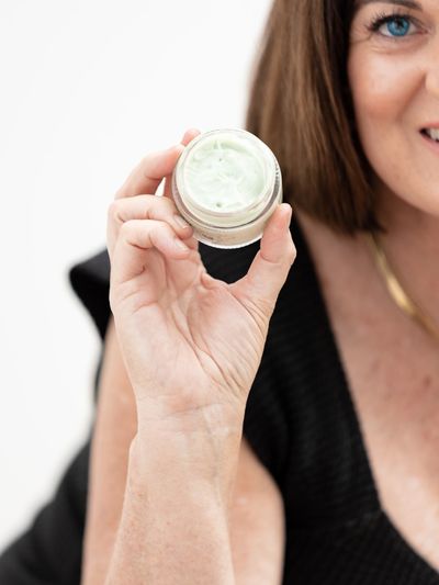 Petal Radiance Skincare Founder Lynn Madyson holding our Cucumber Calming Day  Crème moisturizer