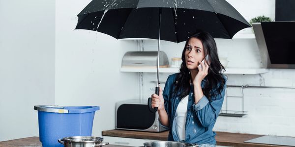 Girl using umbrella to avoid water leaks