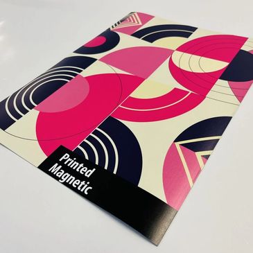 Colorful printed magnetic sheet with geometric patterns in pink, black, and cream.
