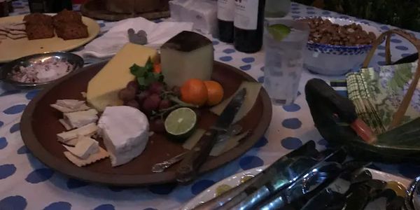 A cheeseboard and bottles of wine. 
