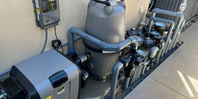 Pool equipment setup with pump, filter, and control panel.