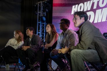Panelists attentively listen during a discussion at a live event.