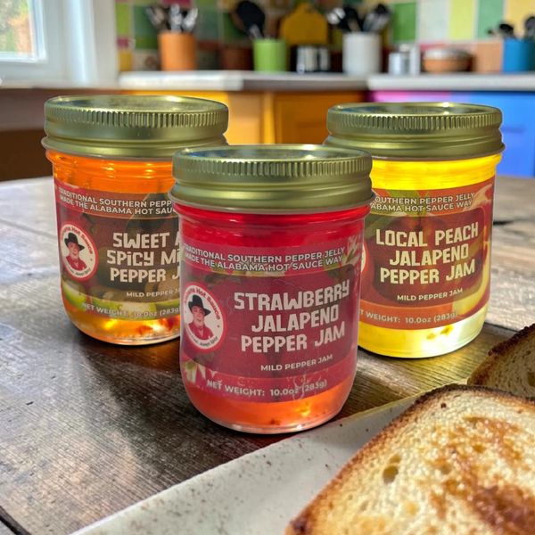 AlabamaHot Sauce Fruit Jalapeno jelly sitting next to a plate of golden brown toast.