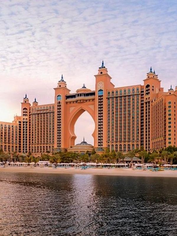 The iconic Atlantis hotel stands grandly by the water at sunset.