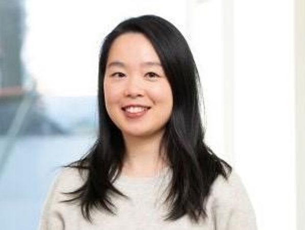 Smiling woman with long black hair.