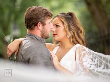 Happy and sexy bride and groom. Veil shot.