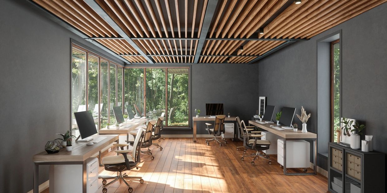 Modern office with wooden ceiling and large windows overlooking greenery.