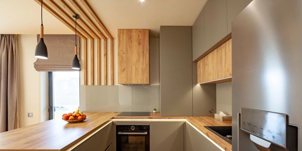 Modern kitchen with wood accents, pendant lights, and neutral tones.