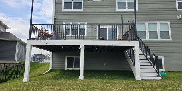 Backyard deck with stairs on a two-story house.