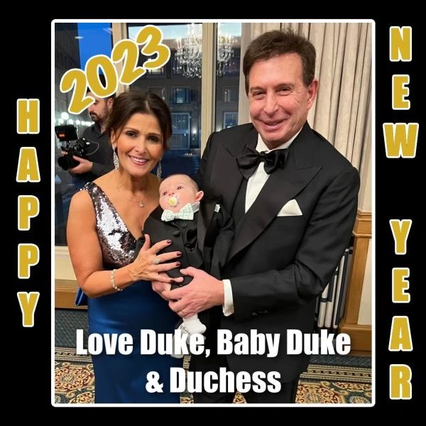 A couple in formal attire holding a baby, wishing a Happy New Year 2023.