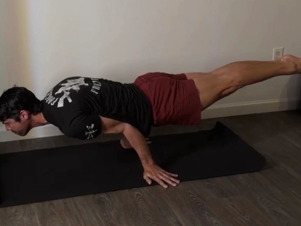 Man doing advanced yoga pose indoors.