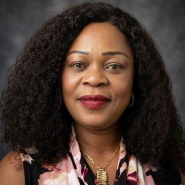 Portrait of a confident woman with curly hair and red lipstick.