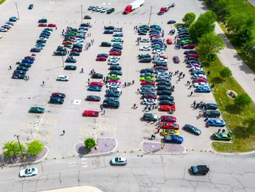 Aerial view of a crowded parking lot with cars parked in rows.