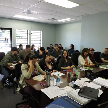 Students in a classroom reading from the text book