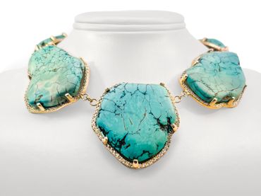 Statement necklace with three large turquoise stones set in gold.