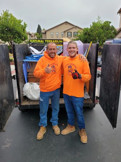 Junk Removal Team standing behind Loaded trailer. Junk Removal Bismarck