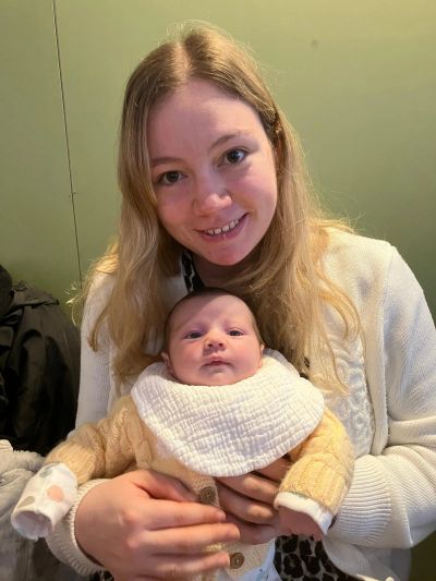 Woman smiling while holding a baby.