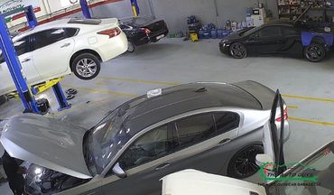 Car repair garage with multiple vehicles being serviced.