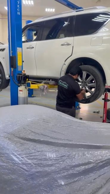 Wheel Alignment & vehicle undergoing routine maintenance service at The Auto Guys Dubai