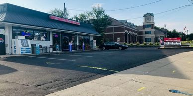 Convenience store near a church with a clock tower.